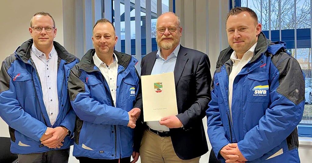 Benjamin Kunze (v.l., Teamleiter Fernwärmenetze und Projektleiter SWB), Heiko Zimmermann (Bereichsleiter Fernwärme und Prokurist SWB), Bernd Schlömer (Staatssekretär) sowie Denny Gerstenberger (technischer Geschäftsführer SWB) bei der Übergabe der Fördermittel. 