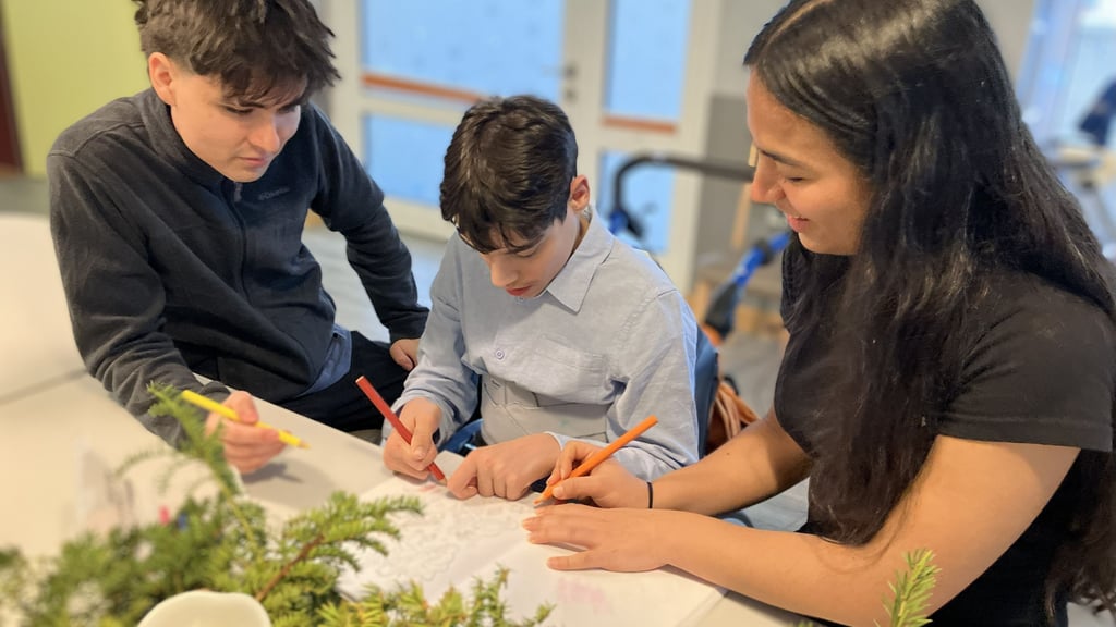 Juan David Aranguren (l.) und Paula Pimzón Morales kümmern sich in der Evangelischen Stiftung Neinstedt auch um Lukas, der sehr gerne malt.