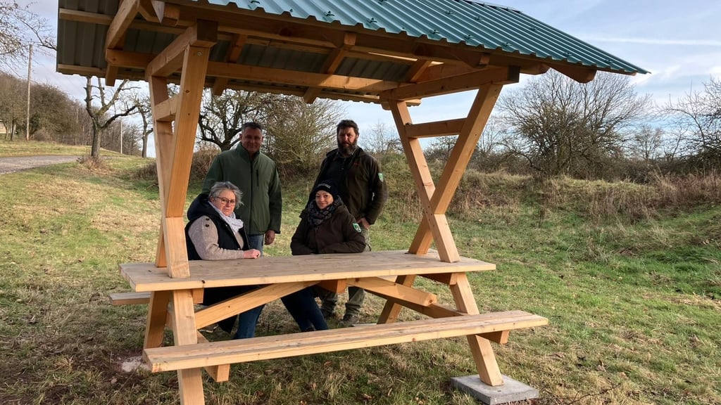 Die Südharzer Ortsbürgermeister Astrid Matschulat und Alexander Fuhrmann sowie Luisa Bleek und Karsten Kühne (v. l. n. r.) von der Verwaltung des Biosphärenreservats bei der Übergabe der neuen Sitzgruppe unterhalb der Schönen Aussicht.