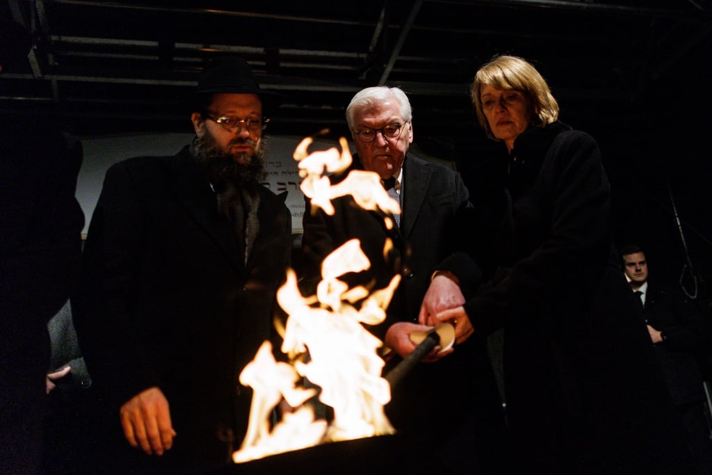 Stunden nach dem brutalen Anschlag in Sydney zündeten Rabbiner Yehuda Teichtal (l), Bundespräsident Frank-Walter Steinmeier und seine Frau Elke Büdenbender gemeinsam eine Fackel für die erste Kerze des Chanukka-Leuchters vor dem Brandenburg Tor an.