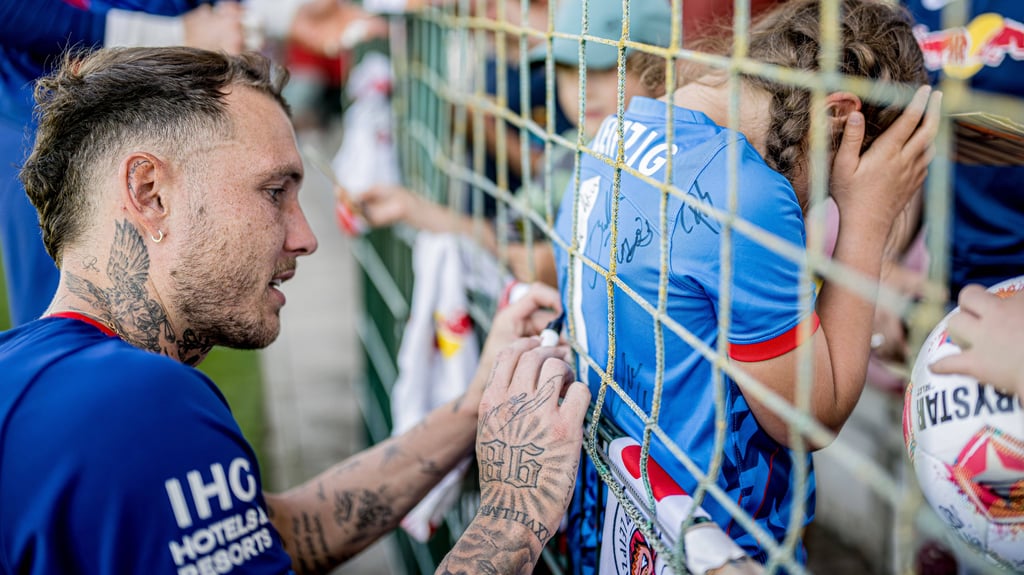 David Raum schreibt beim Training von RB Leipzig Autogramme.