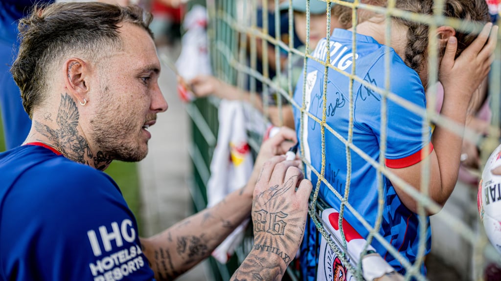 David Raum schreibt beim Training von RB Leipzig Autogramme.