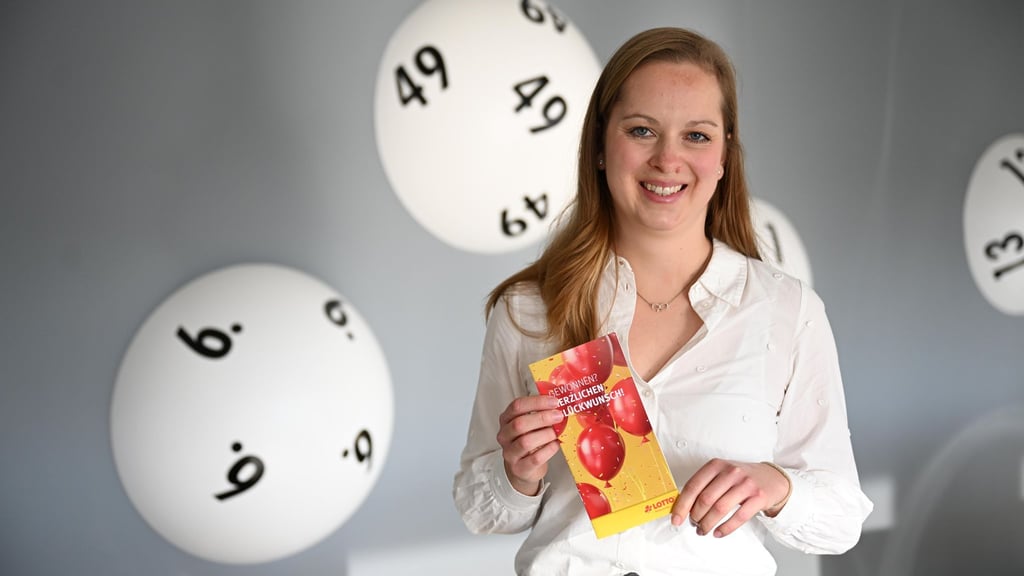 Hannah Strobel von Lotto Niedersachsen zeigt eine Broschüre für Lottogewinner.