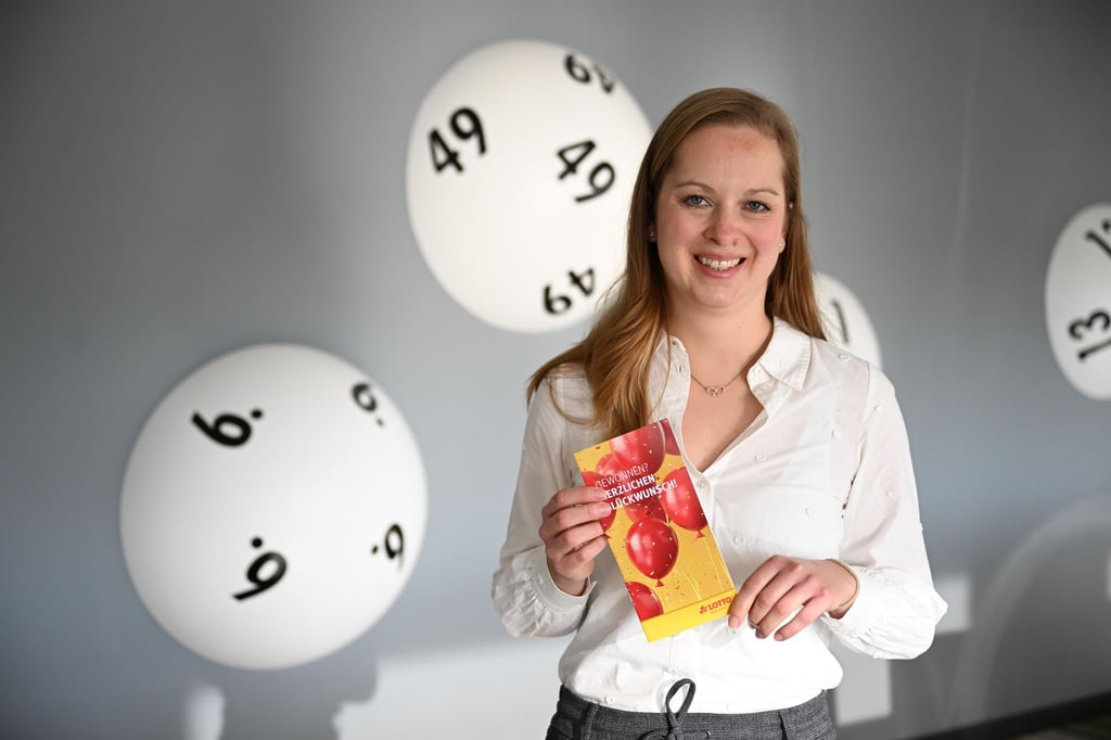 Hannah Strobel von Lotto Niedersachsen zeigt eine Broschüre für Lottogewinner.