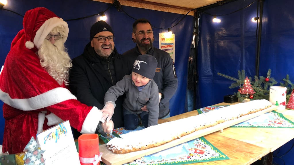 Auf dem Hohenmölsener Weihnachtsmarkt nahm Bürgermeister Andy Haugk (2.v.l.) mit Bäckermeister Jens Leder und dessen vierjährigen Sohn Gustav den traditionellen Stollenanstich vor. Hilfe hatten sie dabei vom Weihnachtsmann. 