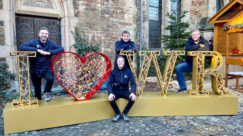 Belohnung nach dem Aufbau: Mitarbeiter der Wernigerode Tourismus GmbH (WTG) probieren den neuen Fotospot auf dem Wernigeröder Weihnachtsmarkt sogleich aus.