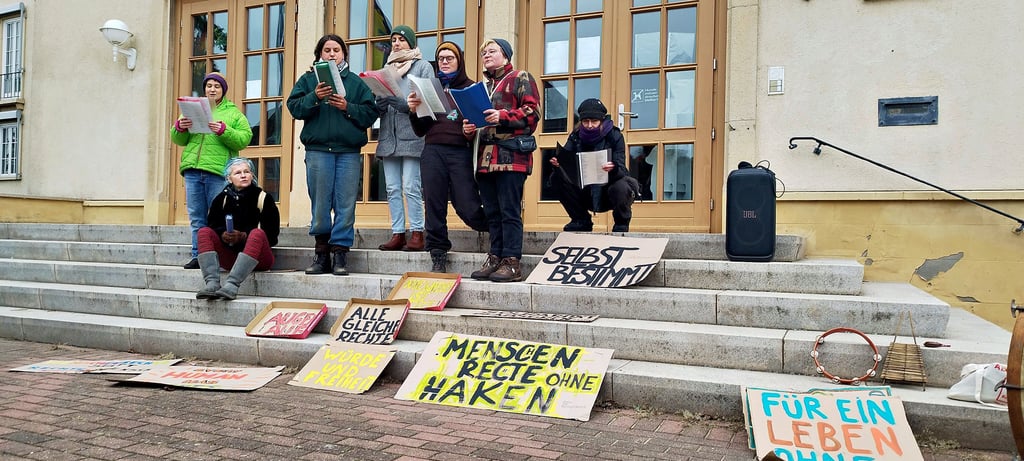 Im Rahmen der Menschenrechtsdemo  in Salzwedel sangen Aktivistinnen vor der Kreisverwaltung, dem Sitz der Ausländerbehörde. Die Demonstranten warfen der Behörde die absichtliche Benachteiligung von Migranten vor. 