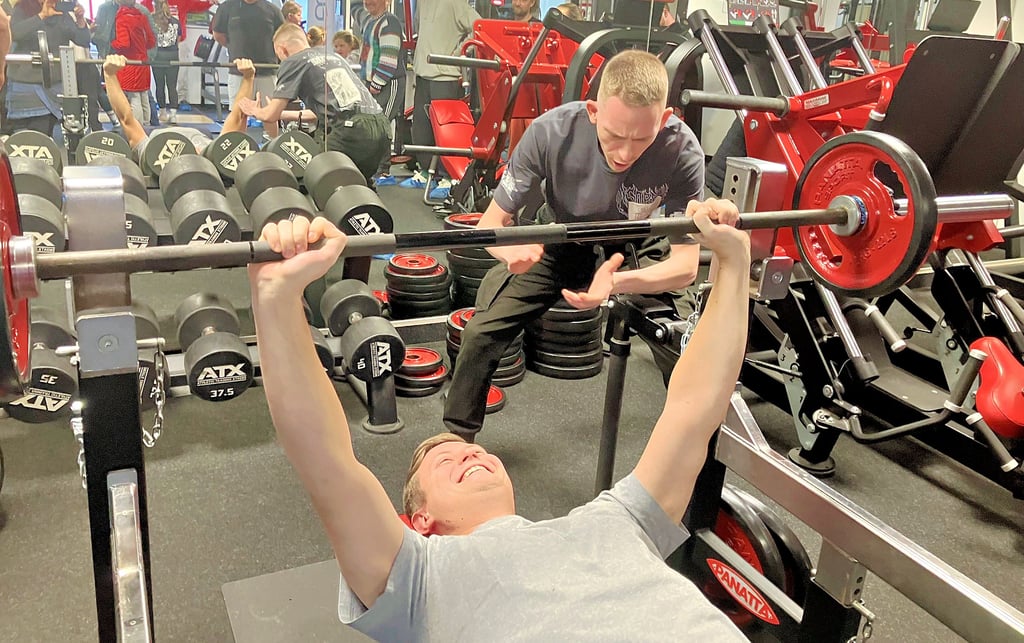 Eric Badstübner wird beim Stemmen der Gewichte auf der Hantelbank angefeuert.