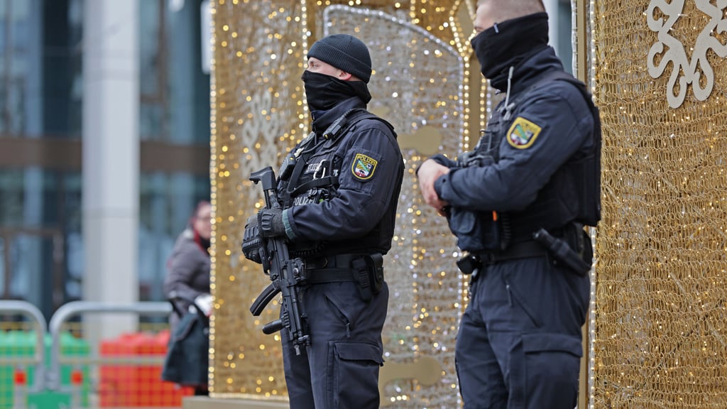 Einsatzkräfte der Polizei stehen auf dem Magdeburger Weihnachtsmarkt. Am ersten Jahrestag des Anschlags auf den Weihnachtsmarkt sichert die Polizei zudem eine Reihe von Gedenkveranstaltungen.