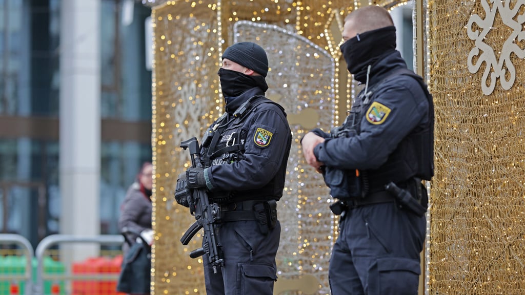 Einsatzkräfte der Polizei stehen auf dem Magdeburger Weihnachtsmarkt. Am ersten Jahrestag des Anschlags auf den Weihnachtsmarkt sichert die Polizei zudem eine Reihe von Gedenkveranstaltungen.