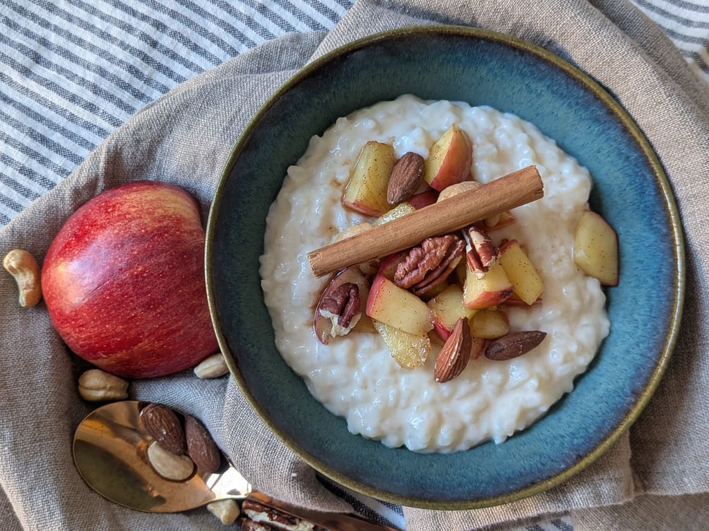 Der Milchreis ist mit Apfel, Zimt und Nüssen getoppt und eignet sich sowohl als Hauptspeise als auch als Dessert.
