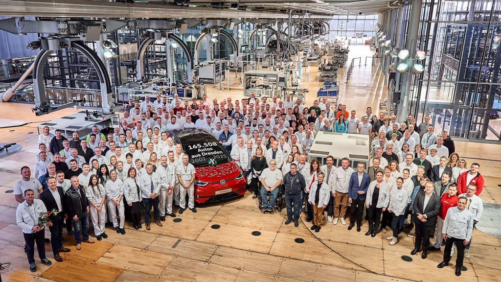 Die Beschäftigten stehen in der Gläsernen Manufaktur von Volkswagen vor einem roten ID.3, der als letztes Auto vom Band gerollt ist. Das Auto wurde von allen Beschäftigten signiert und soll als Ausstellungs- und Erinnerungsstück im Werk bleiben. Nach 24 Jahren endet die Autoproduktion in der Gläsernen Manufaktur.