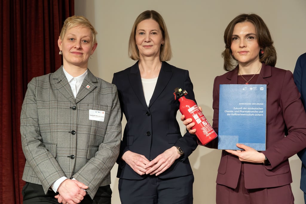 Gewerkschaftlerin Stephanie Albrecht-Suliak und Arbeitgeberchefin Nora Schmidt-Kesseler übergeben sybolisch einen Feuerlöscher an die Ostbeauftragte der Bundesregierung, Elisabeth Kaiser.