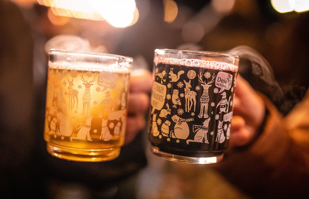 Zwei Menschen stoßen mit Glühwein an – ein Vorgeschmack auf die winterliche Stimmung des Adventsmarkts.