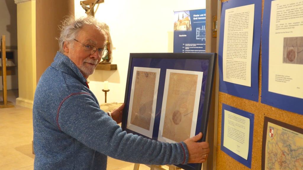Mit dem letzten Handgriff fügt Michael Löderbusch der Ausstellung in der Groß Ammensleber Kirche eine Kopie des Originals der Friedrich-Urkunde über Abt Karl Rieke hinzu.