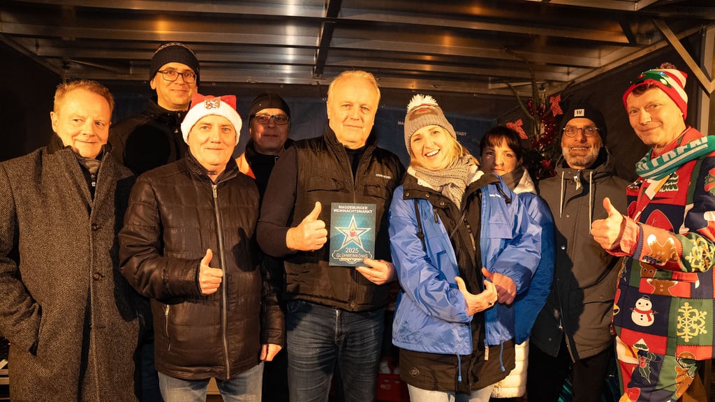 Glühweinkönig 2025 auf dem Weihnachtsmarkt Magdeburg Ralf Hedt (Mitte mit Urkunde) mit Mitbewerbern und Juryteilnehmern.