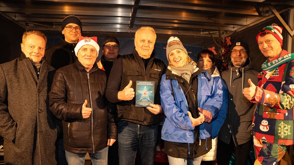 Glühweinkönig 2025 auf dem Weihnachtsmarkt Magdeburg Ralf Hedt (Mitte mit Urkunde) mit Mitbewerbern und Juryteilnehmern.