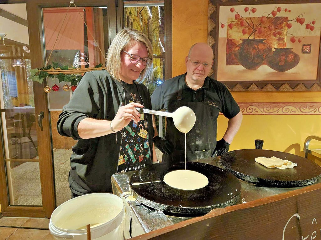 Profis unter sich: Hochschulmitarbeiterin Kathleen Wismach hat beim Backen der Crêpes ziemlich viel Routine, wie Martin Wessely unschwer erkennt.
