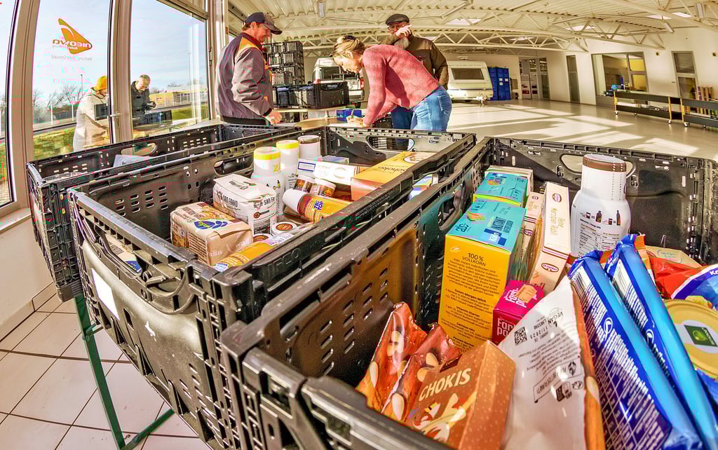 Mitarbeiter der Köthener Sozial- und Arbeitsförderungs gGmbH (KöSAG) geben Lebensmittel aus an bedürftige Menschen.