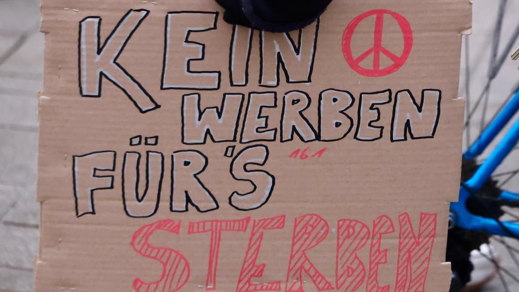 Mit selbst gebastelten Plaketen wehren sich auf der Demo in Halle Schüler gegen die Wehrpflicht.