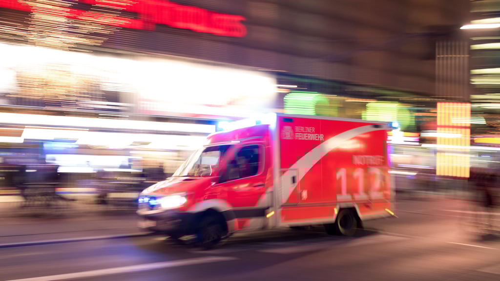 Ein Rettungswagen der Feuerwehr rast mit Blaulicht durch die Stadt.
