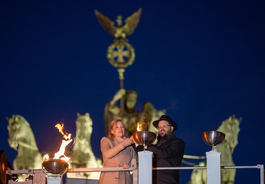 Bundestagspräsidentin Julia Klöckner und Rabbiner Yehudi Teichtal entzünden ein Licht.