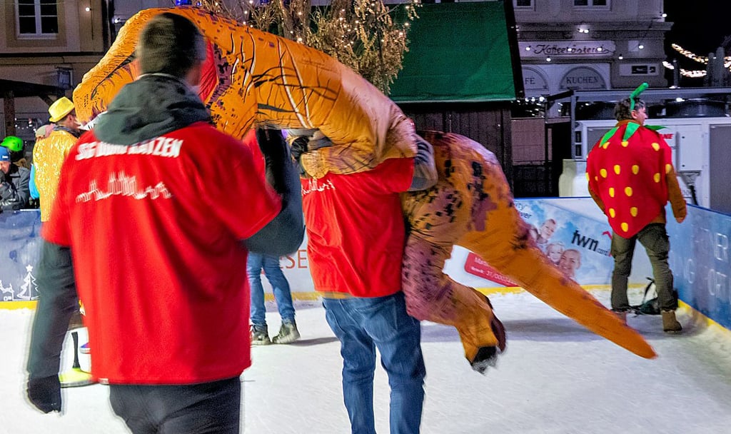 Erschöpfter Dino: Die „Domfratzen“ als Silbermedaillengewinner  tragen ihr Maskottchen vom Eis (unter dem Kostüm befand sich Citymanagerin Sarah Gratz).