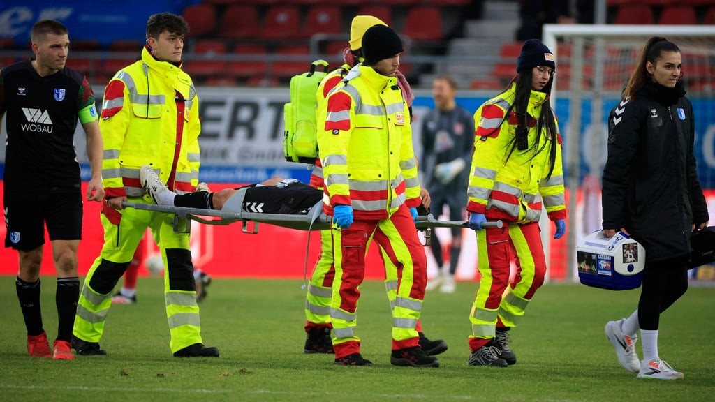 Eldin Dzogovic wird beim Spiel des 1. FC Magdeburg II in Halle mit einer Knieverletzung vom Feld getragen.