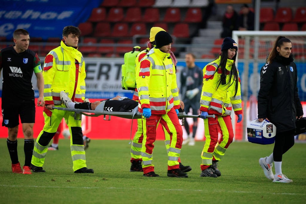 Eldin Dzogovic wird beim Spiel des 1. FC Magdeburg II in Halle mit einer Knieverletzung vom Feld getragen.