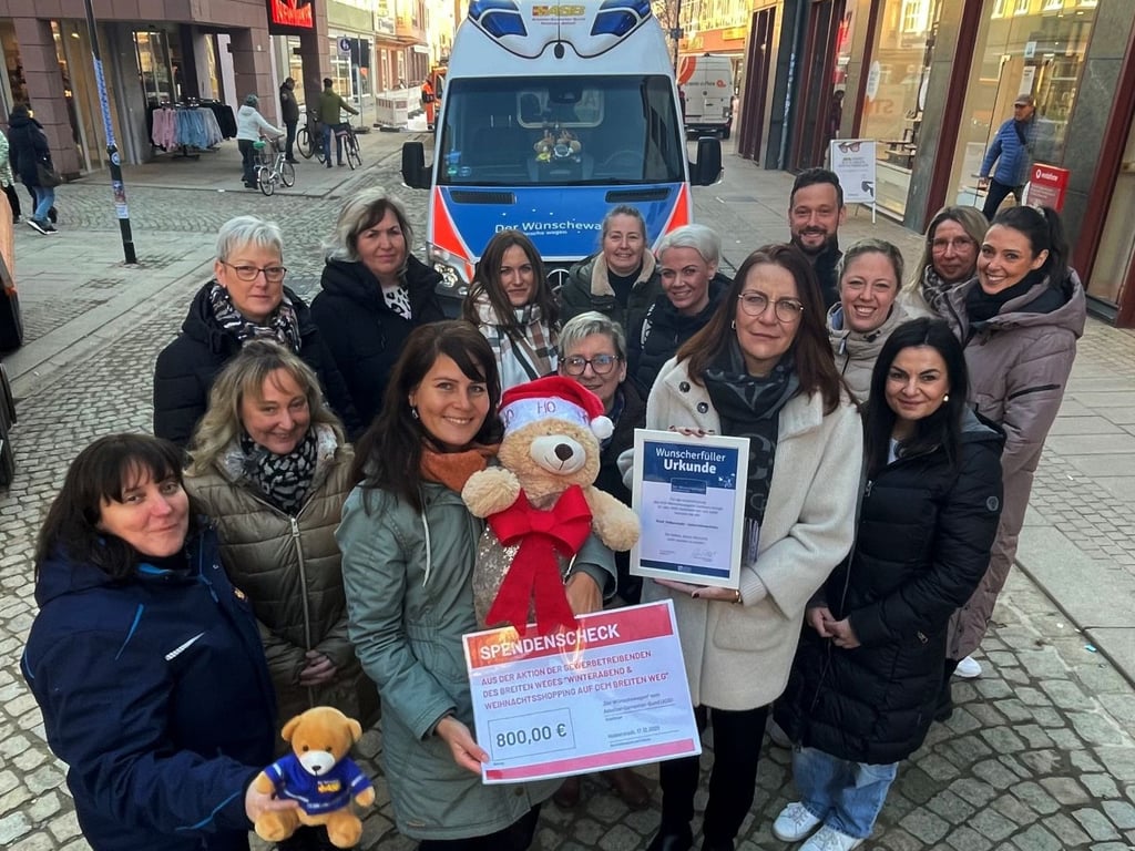 Einige der Gewerbetreibenden vom Breiten Weg Halberstadt und Mitarbeiter des ASB vor dem Wünschewagen.