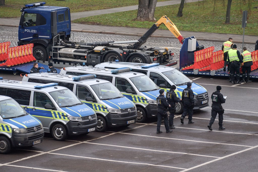 Am Morgen des Gedenktags in Magdeburg entladen Polizisten Straßensperren auf einem Parkplatz nahe der Johanniskirche.&nbsp;
