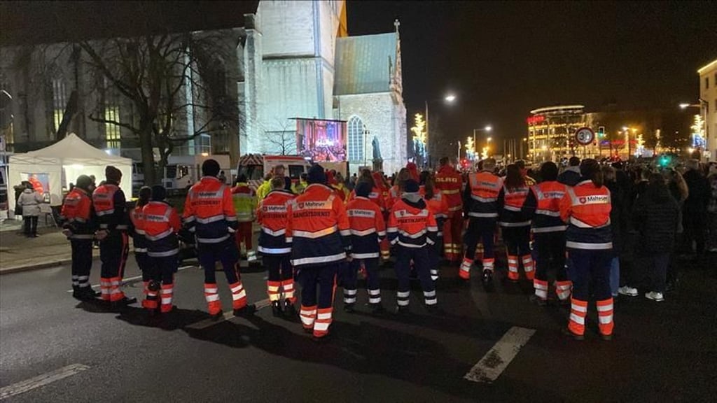 Zahlreiche Helfer von DLRG, Malteser und ASB verfolgen die Veranstaltung auf der Straße vor der Kirche.