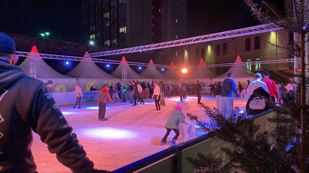 Während der Gedenkstunde laufen einige Menschen vor der Festung Mark Schlittschuh.