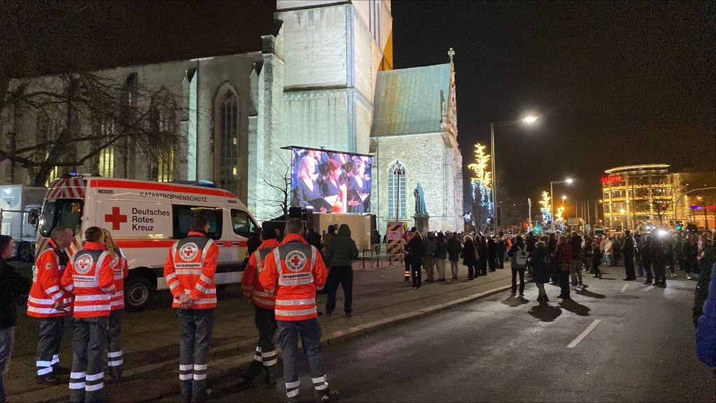 Die Gedenkstunde in der Johanniskirche in Magdeburg wird über Bildschirme nach draußen übertragen.