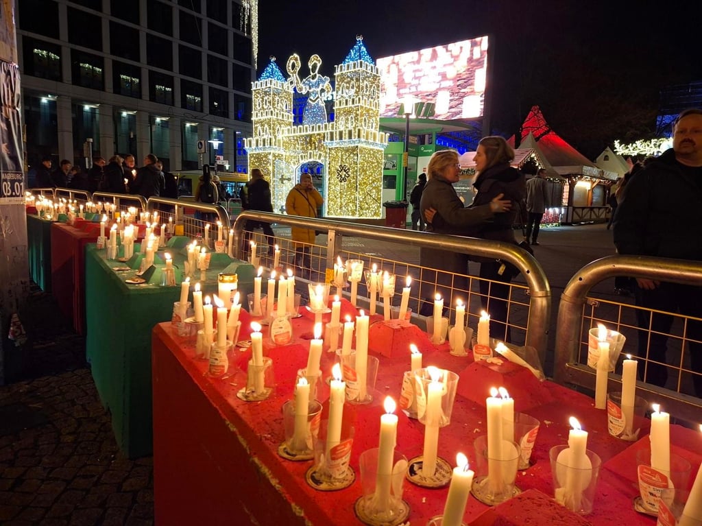 Nach der Lichterkette stellten viele Magdeburger die Kerzen auf den grün-roten Absperrblöcken rund um den Weihnachtsmarkt auf.