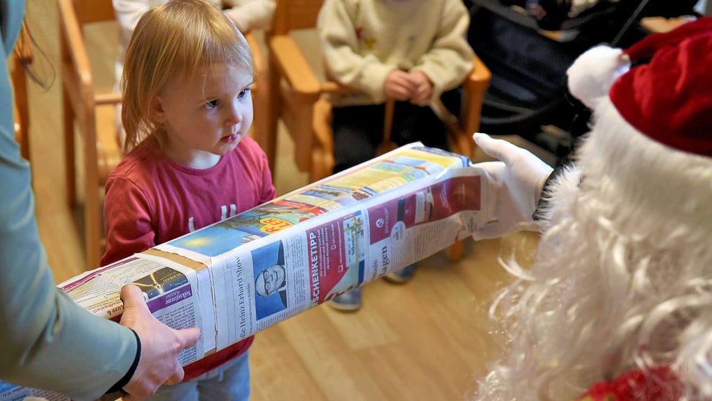 Für die Krippenkinder hat der Weihnachtsmann Geschenke mitgebracht, die in Zeitungspapier eingewickelt sind. Erzieherin Luisa besuchte zuvor einen Lehrgang, in dem es um Nachhaltigkeit ging. 