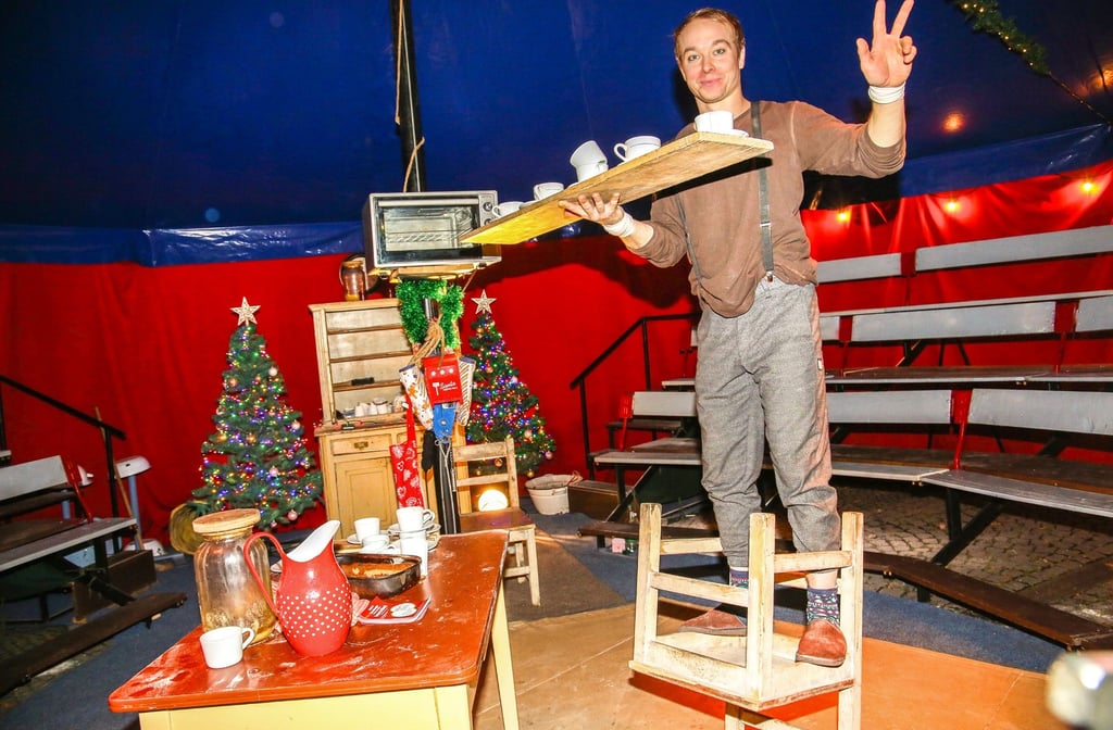 Michal Mudrák balanciert auf einer Stuhllehne ein Tablett mit Kaffeetassen. Der Spitzenakrobat aus Tschechien gibt noch bis zum 3. Januar Vorstellungen in seinem Weihnachtszirkus auf dem Bernburger Karlsplatz.