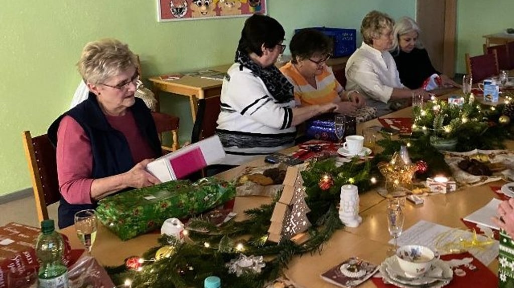 Mitglieder der wiedergegründeten Ortsgruppe der Volkssolidarität beim Auspacken von Weihnachtsgeschenken.