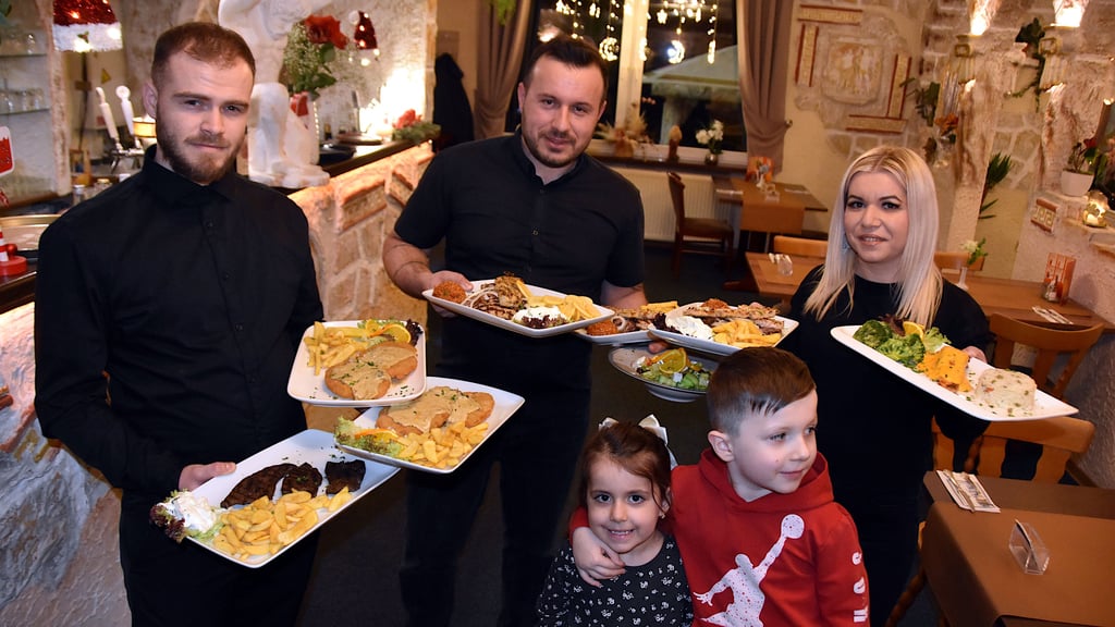 Festliche Vorfreude: Mark Marku (2. v. l.) zeigt zusammen mit seiner Frau Maniola Koletsi und seinen Kindern Riana und Rayan sowie Kellner Arianis Llika die köstlichen Weihnachtsgerichte, mit denen das Restaurant „Herkules“ in Erxleben seine Gäste in festlicher Atmosphäre verwöhnt.