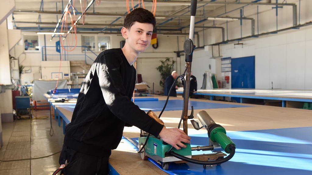 Adrian Lichner arbeitet an einer Lkw-Plane. Der junge Fahrzeugsattler ist Landessieger in seinem Gewerk geworden.