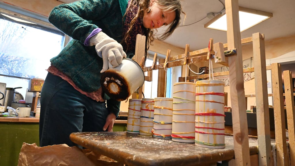 Anja Keßler gießt Stumpenkerzen in ihrer Manufaktur.