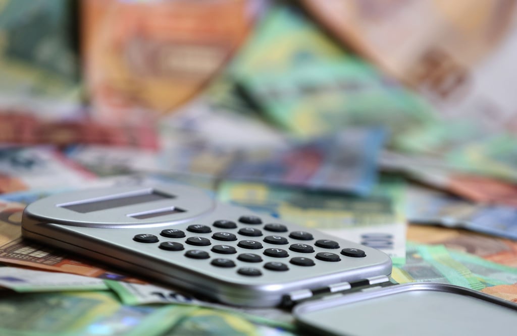 Ein Taschenrechner liegt auf verschiedenen Euro-Banknoten. (Symbolbild)