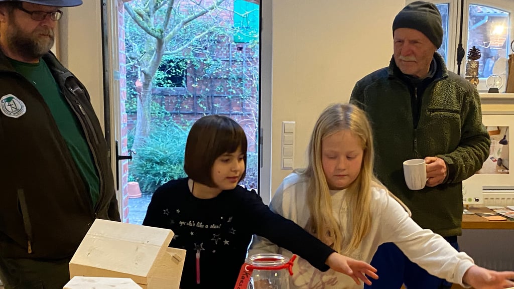 Umweltbildung in Aktion: Ranger Ralf Bertram (links) zeigt Carlotta und Jolena, wie ein Futterhäuschen zusammengebaut wird, während Gastgeber Jörg Lauenroth-Mago kurz zuschaut.