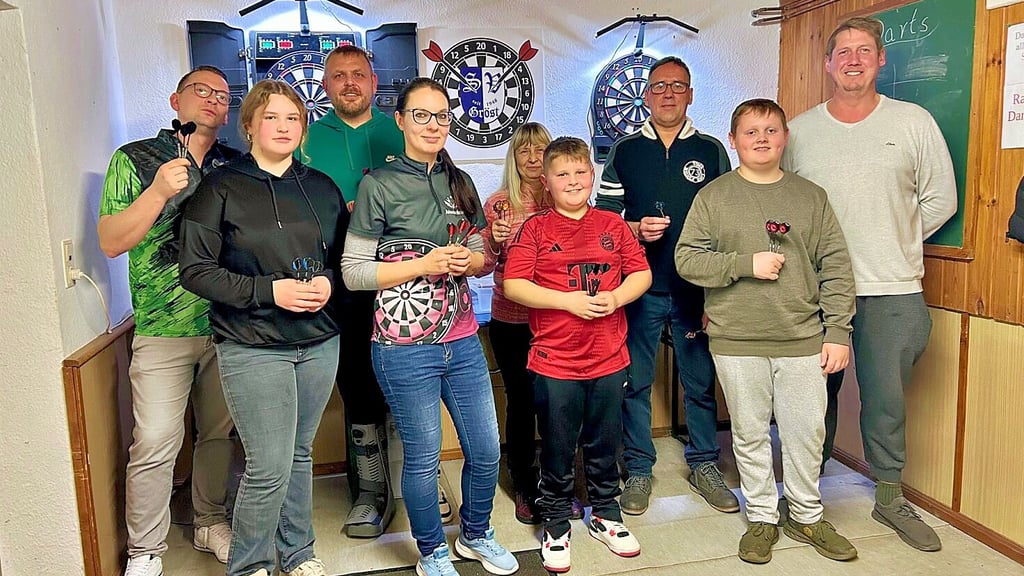 Das sind die ersten Mitglieder der neuen Sektion Darts des SV Gröst. Ein selbst entwickeltes Logo (im Hintergrund) gibt es bereits.  