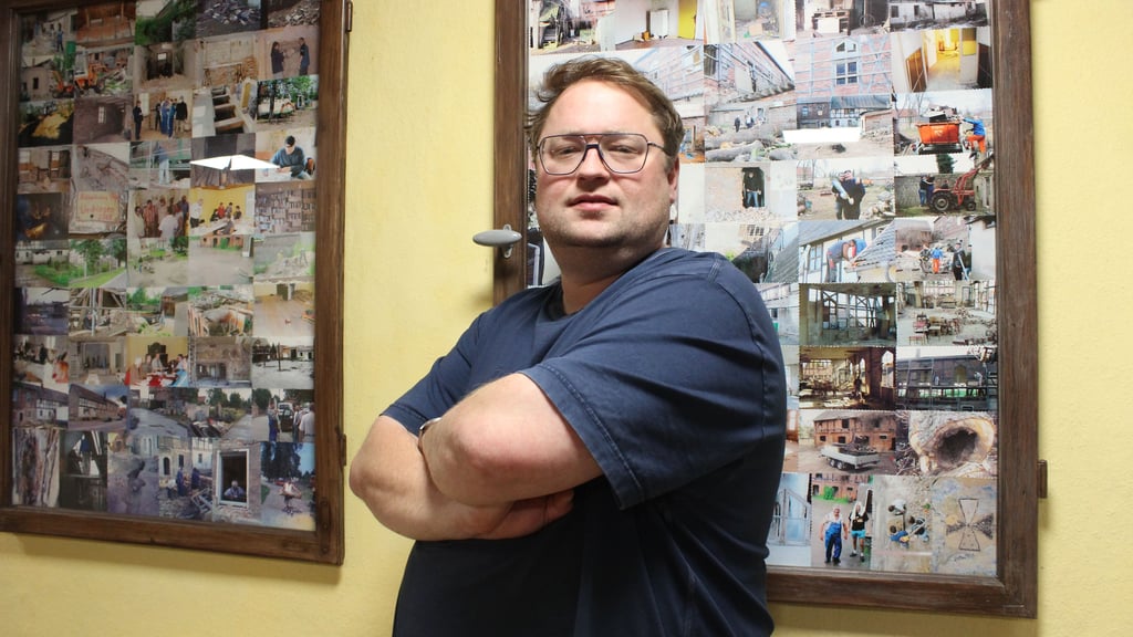 Der Ortsbürgermeister aus Wedringen, André Wiklinski, steht in der Bibliothek des Dorfgemeinschaftshauses. Aus alten Fenstern wurden Kunstwerke mit Bildern der Sanierung des Hauses gefertigt. 