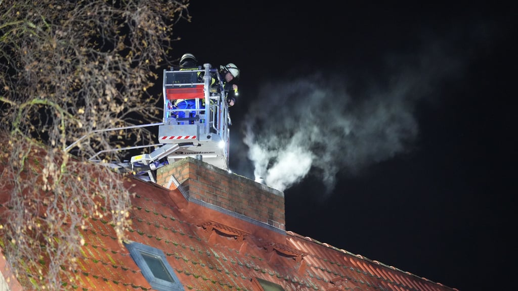 Rauch zieht am 27. Dezember aus einer Wohnung in der Sachsenstraße in Stendal. Einsatzkräfte der Freiwilligen Feuerwehr Stendal kontrollieren von der Drehleiter aus, ob sich ein Brandherd im Schornstein befindet.