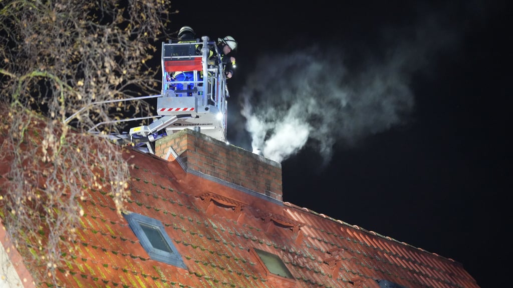 Rauch zieht am 27. Dezember aus einer Wohnung in der Sachsenstraße in Stendal. Einsatzkräfte der Freiwilligen Feuerwehr Stendal kontrollieren von der Drehleiter aus, ob sich ein Brandherd im Schornstein befindet.