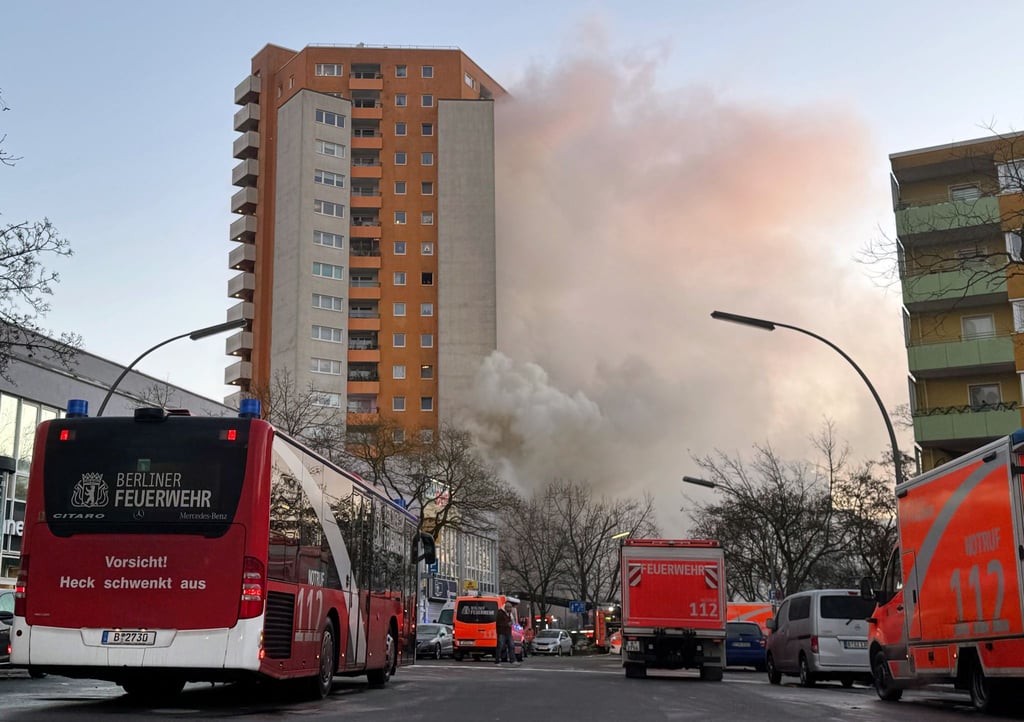 Rettungskräften vor dem brennenden Hochhaus in Berlin-Spandau.