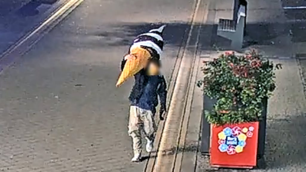 Eine riesige Eistüte wird von einem Mann durch Burg getragen. Er wird kurz darauf gestellt. 