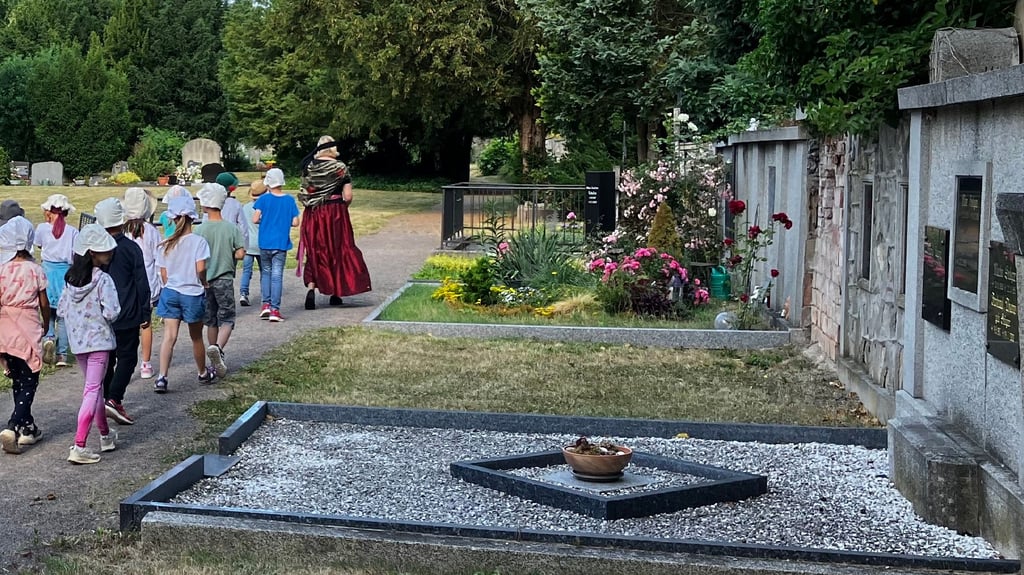 Gottesacker als Ort der Geschichte: Bettina Fügemann erklärt Kindern bei einer historischen Friedhofsführung im Sommer 2025, welche historischen Persönlichkeiten in Ballenstedt begraben sind.
